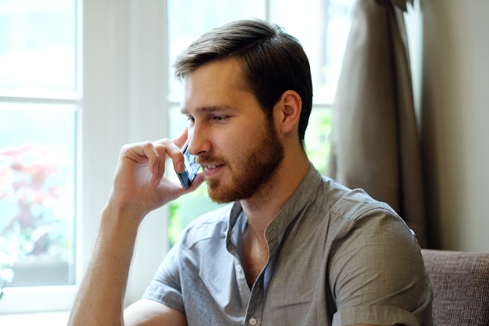 homme-souriant-en-attente-au-telephone